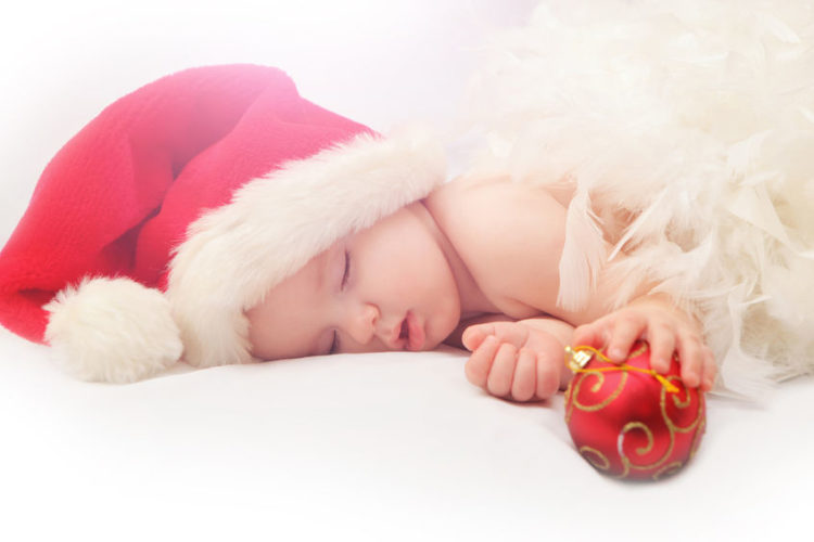 39540528 - sleeping baby santa claus red hat and holding christmas tree decoration